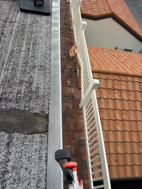 Gutter cleaning service removing debris from residential roof gutters in Sarasota Florida