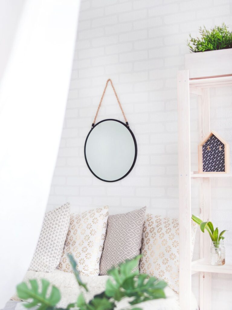 Large decorative round mirror securely mounted on a living room wall