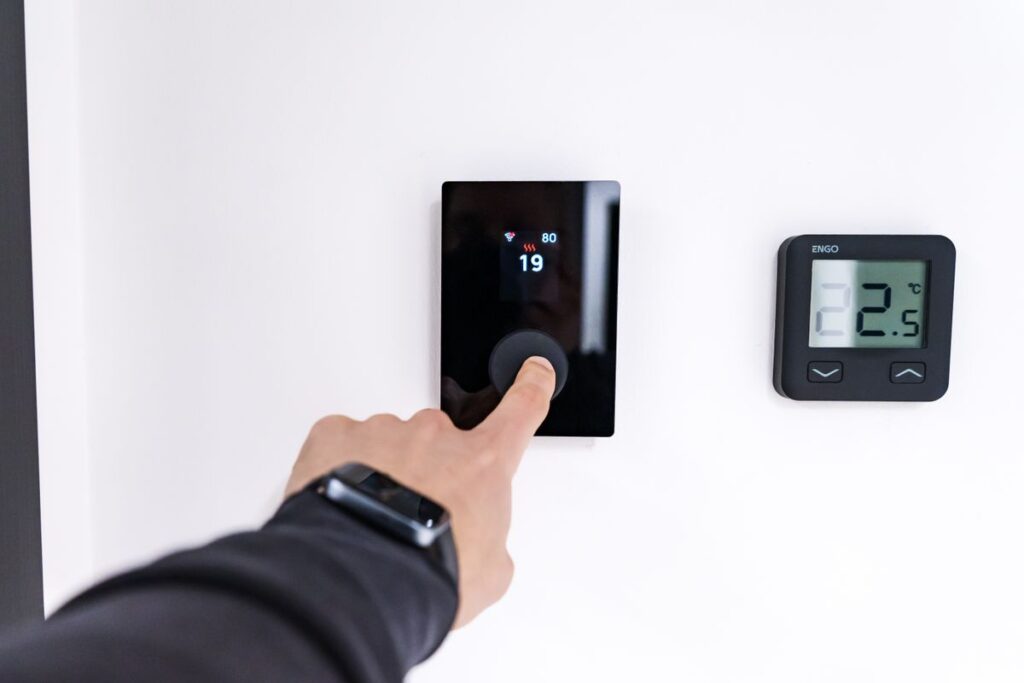 Hand adjusting a flush wall-mounted smart thermostat