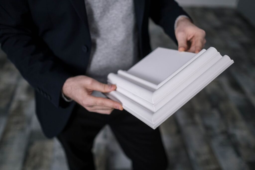 Handyman holding a baseboard trim molding profile sample