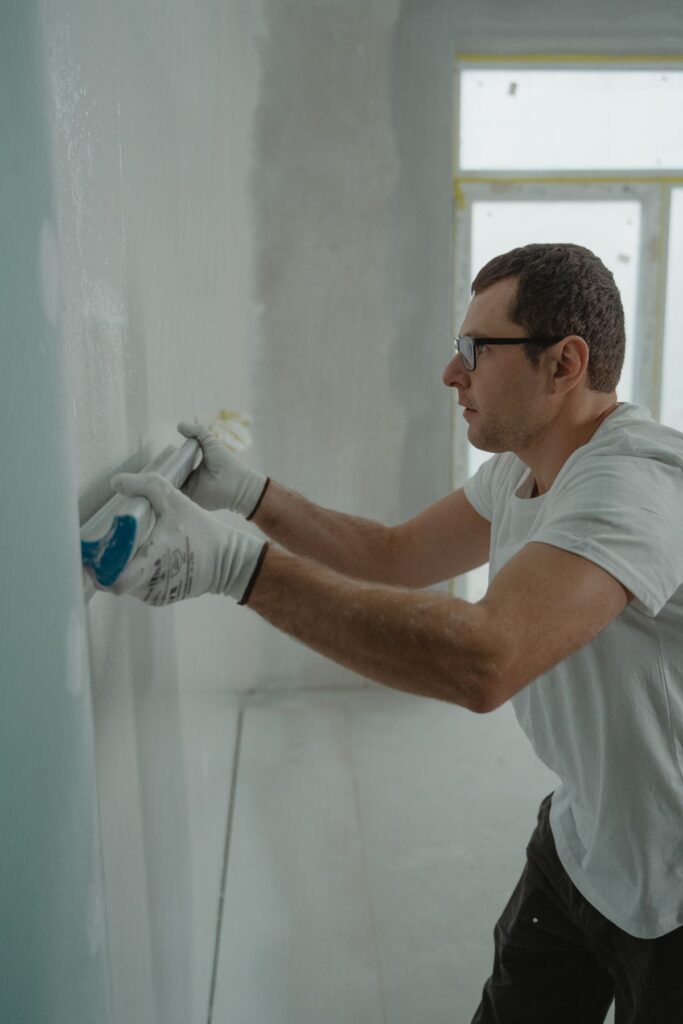 Applying drywall compound to patch and smooth an interior wall