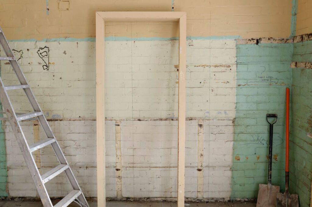 Interior room mid tear-out with tools and partially removed wall finishes