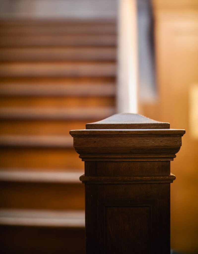 Detail of a wooden stair handrail and newel post